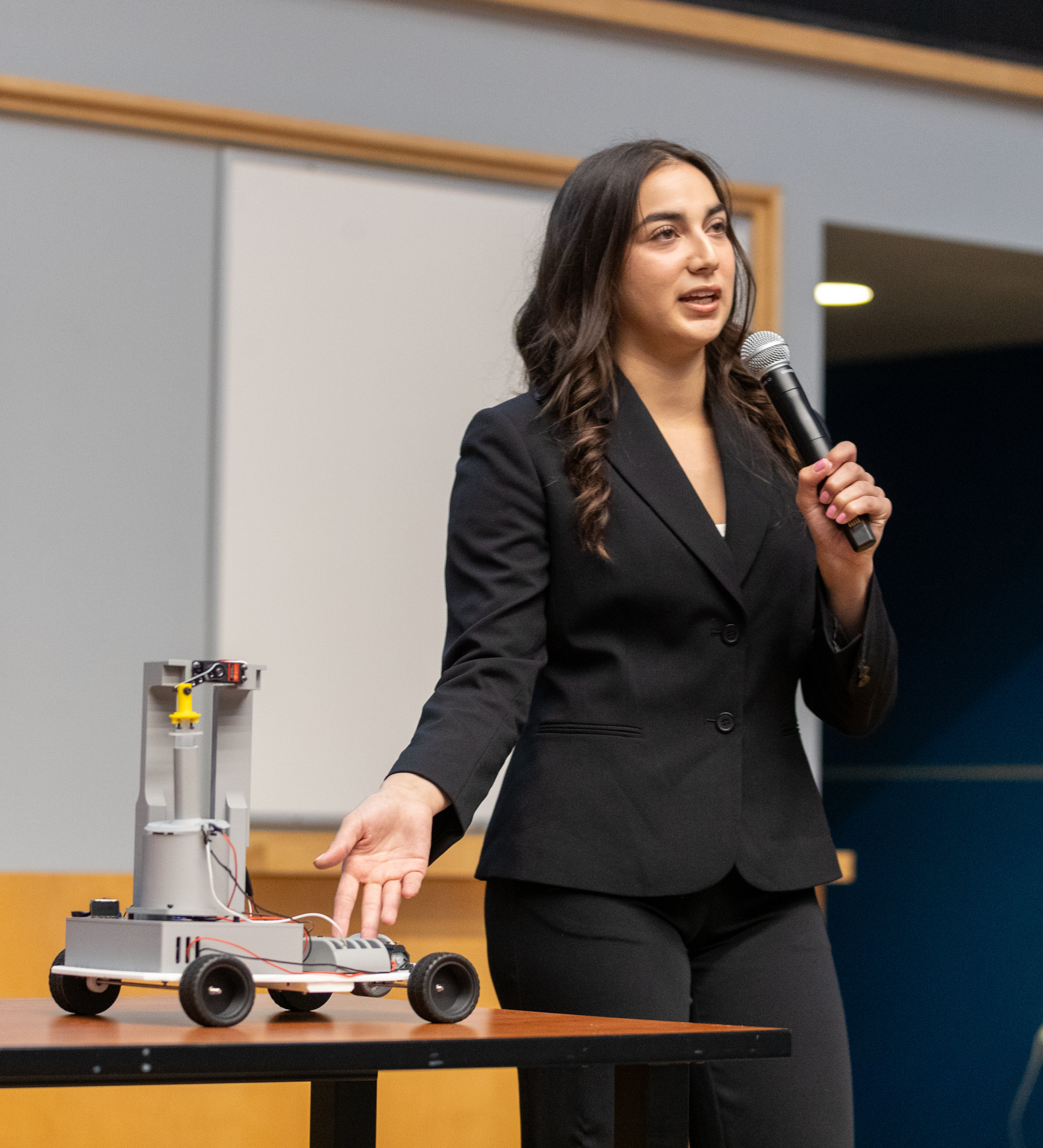 Student presenting an engineering prototype at a university showcase