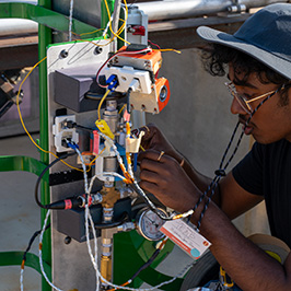 Engineering student working on the electrical systems of a rocket.
