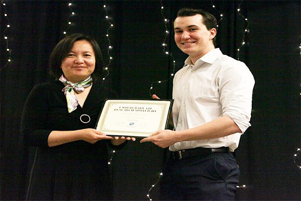 2025 Masquerade Gala Dr. Huinan Liu presenting an award to a student
