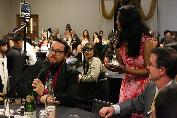 2025 Masquerade Gala students sitting at tables, dressed in semi-formal attire and wearing masks
