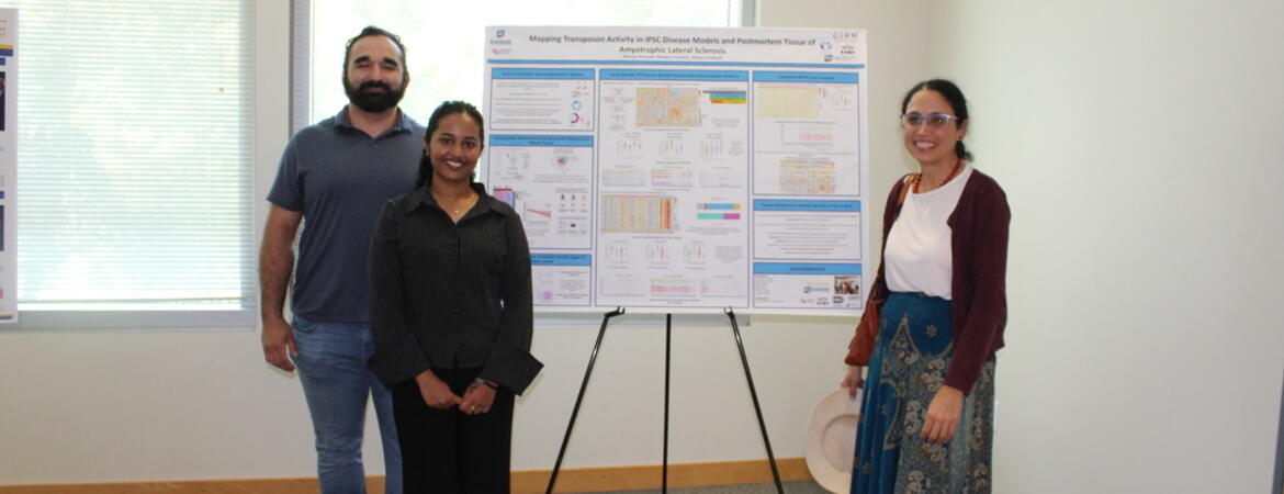 Three participants pose beside a research poster at the BCOE Summer Research Symposium.