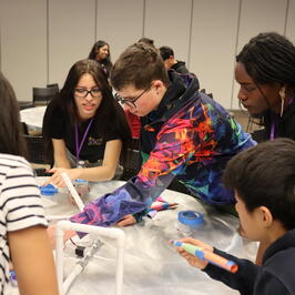 engineering and elementary students working on a project 