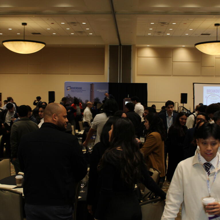 BCOE students and alumni in the main conference room mingling. 