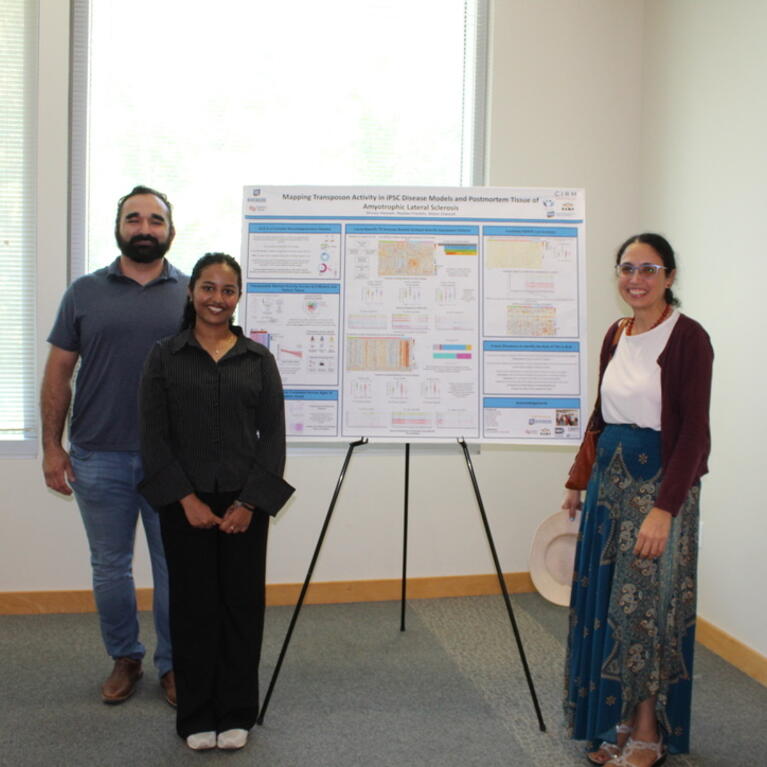 Three participants pose beside a research poster at the BCOE Summer Research Symposium.