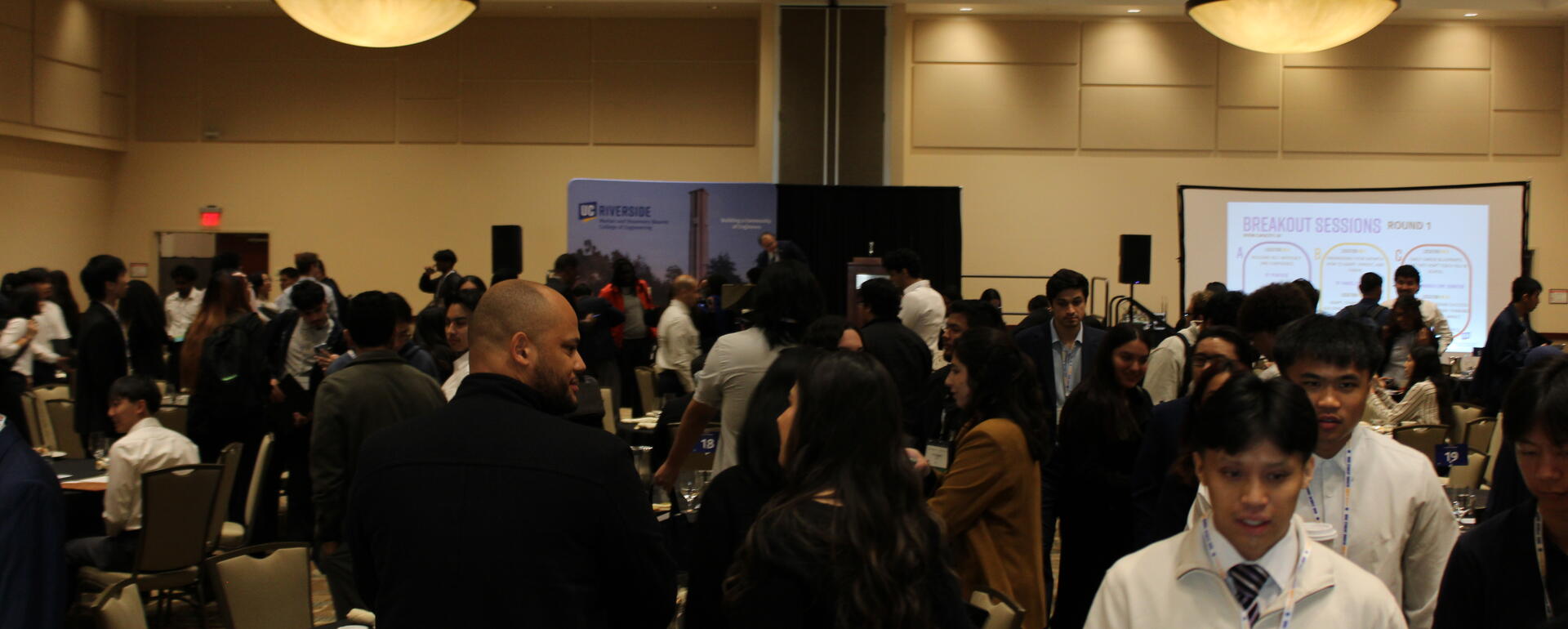 BCOE students and alumni in the main conference room mingling. 
