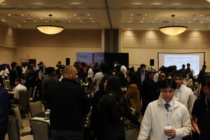 BCOE students and alumni in the main conference room mingling. 