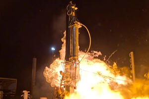 Photo showing the nightime launch of a rocket with flames surrounding the rocket.