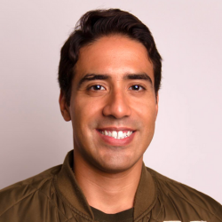 Smiling man with brown hair wearing a brown shirt 