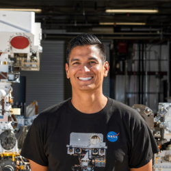 Man wearing a black t-shirt with the nasa logo standing in front of equipment