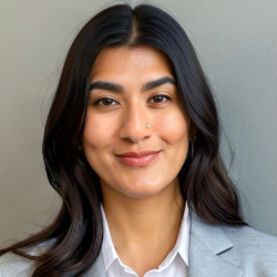 The file shows a headshot of Shamia Khan, a woman with dark, wavy hair and a nose piercing, smiling faintly. She is wearing a white collared shirt under a light gray blazer. The background is a solid gray wall.