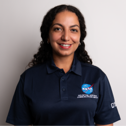 Sirina Nabhan, a breakout session speaker, smiling at the camera. She is wearing a navy blue polo shirt with a NASA logo.