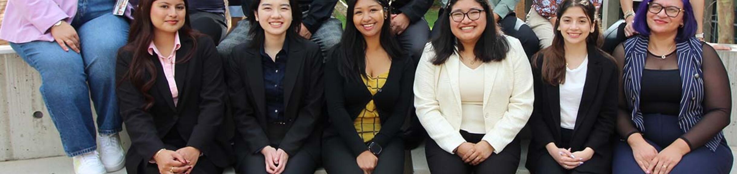 student mentors and professional staff in business attire posing outdoors