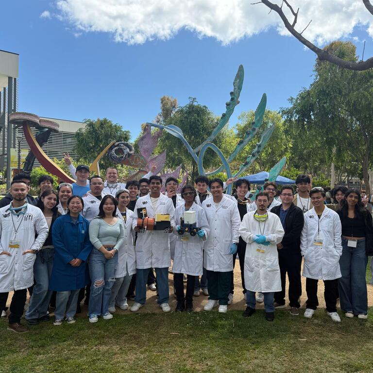 members of AIChE posing together with their project wearing PPE