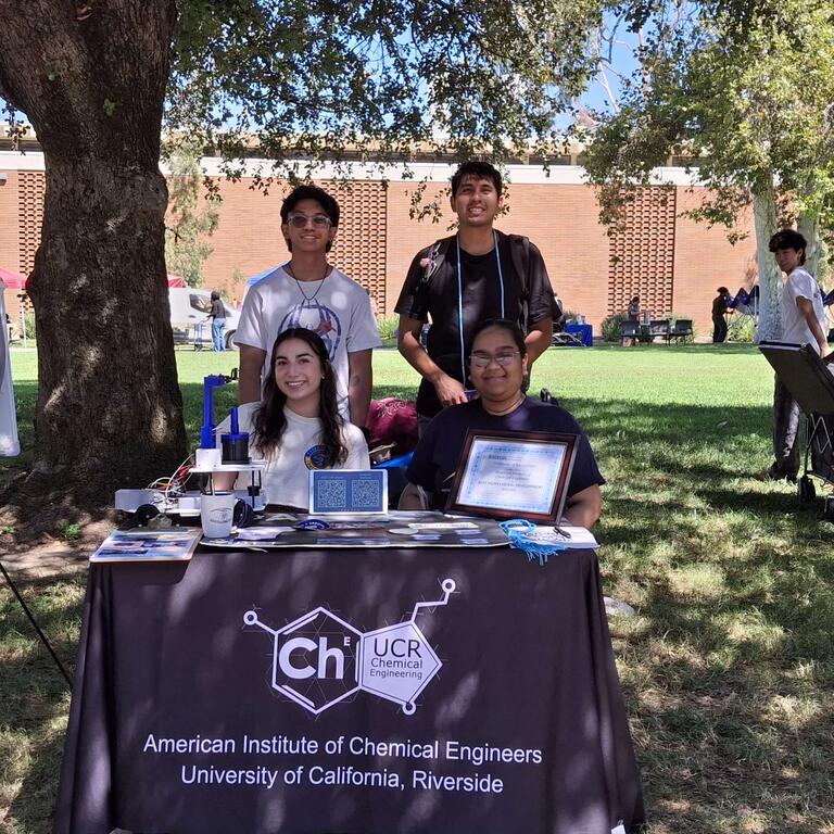 members of AIChE posing outdoors beneath a shade tree