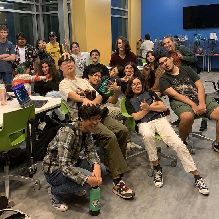 men and women casually dressed and sitting striking comical poses  