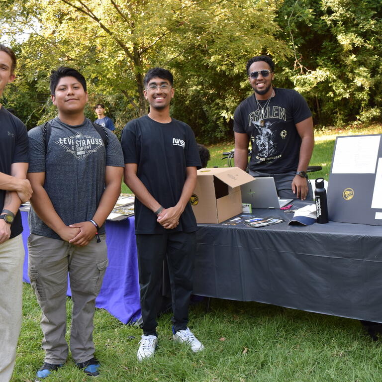 Members of Material Research Society standing by their table 