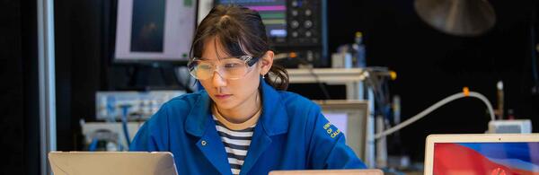 Engineering student looking at a computer in a lab.