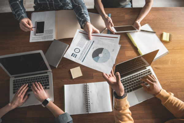 overhead of computers and notes on conference table