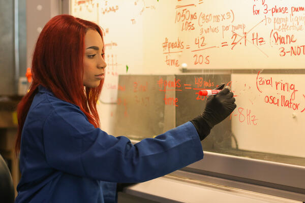 UCR BCOE bioengineering doctoral student Samantha Robinson writing on a dry erase board.