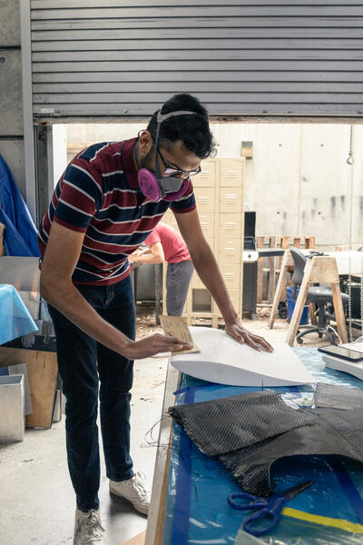  Ani sanding a resin coated foam wing mold in preparation for carbon fiber coating for the Highlander Racing, FSAE car.