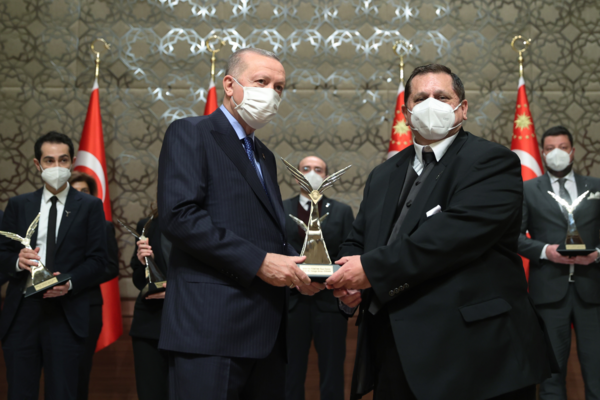 cengiz ozkan shaking hands receiving award