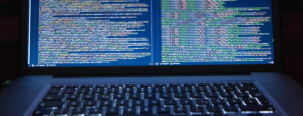 Photo of open laptop computer showing computer code.