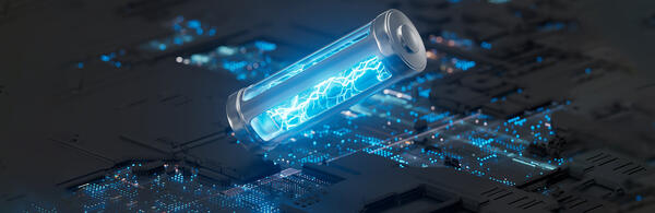 An illustration of a glowing blue battery with lightning bolts inside lies diagonally across a dark circuit board
