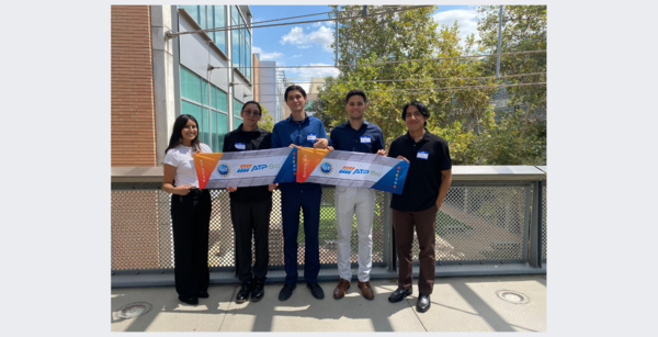 five students holding an ATP bio sign on the Bourns Bridge