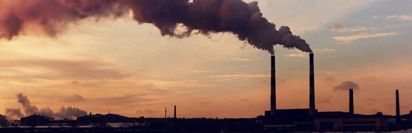 Two factory smokestacks blowing pollution