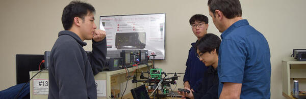 Image of engineering professor working with three students