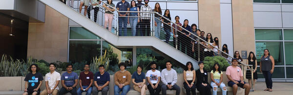 Photo of a group of several dozen data science students posing for a group photo in courtyard