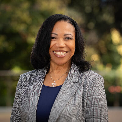 Gwendolyn Thibeaux smiling and wearing a grey jacket and navy top