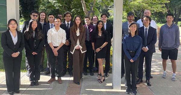 men and women members of Tau Beta Pi posing outdoors most wearing business attire