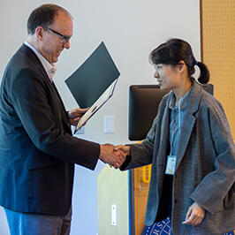 Photo of UCR Engineering Dean Chris Lynch shaking hands with FAME participant Yawen He