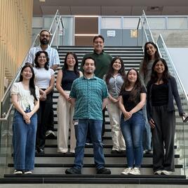 Student and faculty researchers  Group of student researchers and faculty posing on stairs
