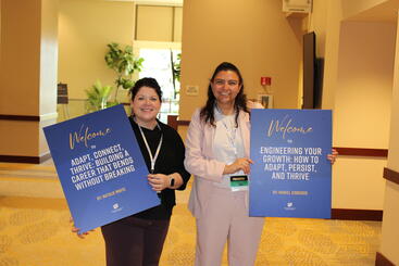 Mariel Cisneros and Natalie White holding up their signs to their workshops at the IGNITE Conference