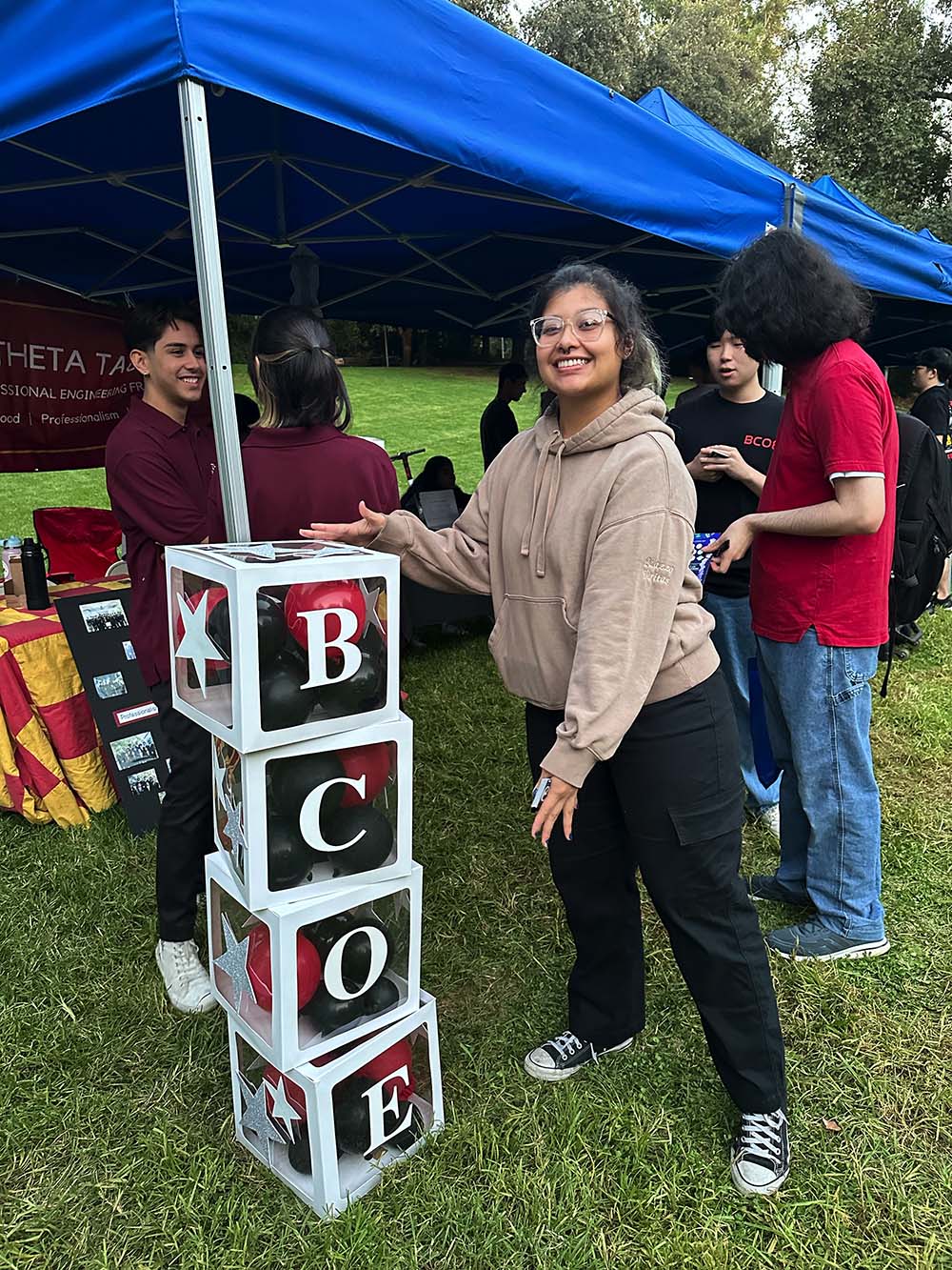 Theta Tau student standing by a BCOE decoration
