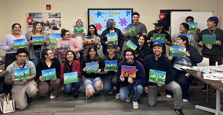 Transfer students in the Transfer Student Center holding painted canvases