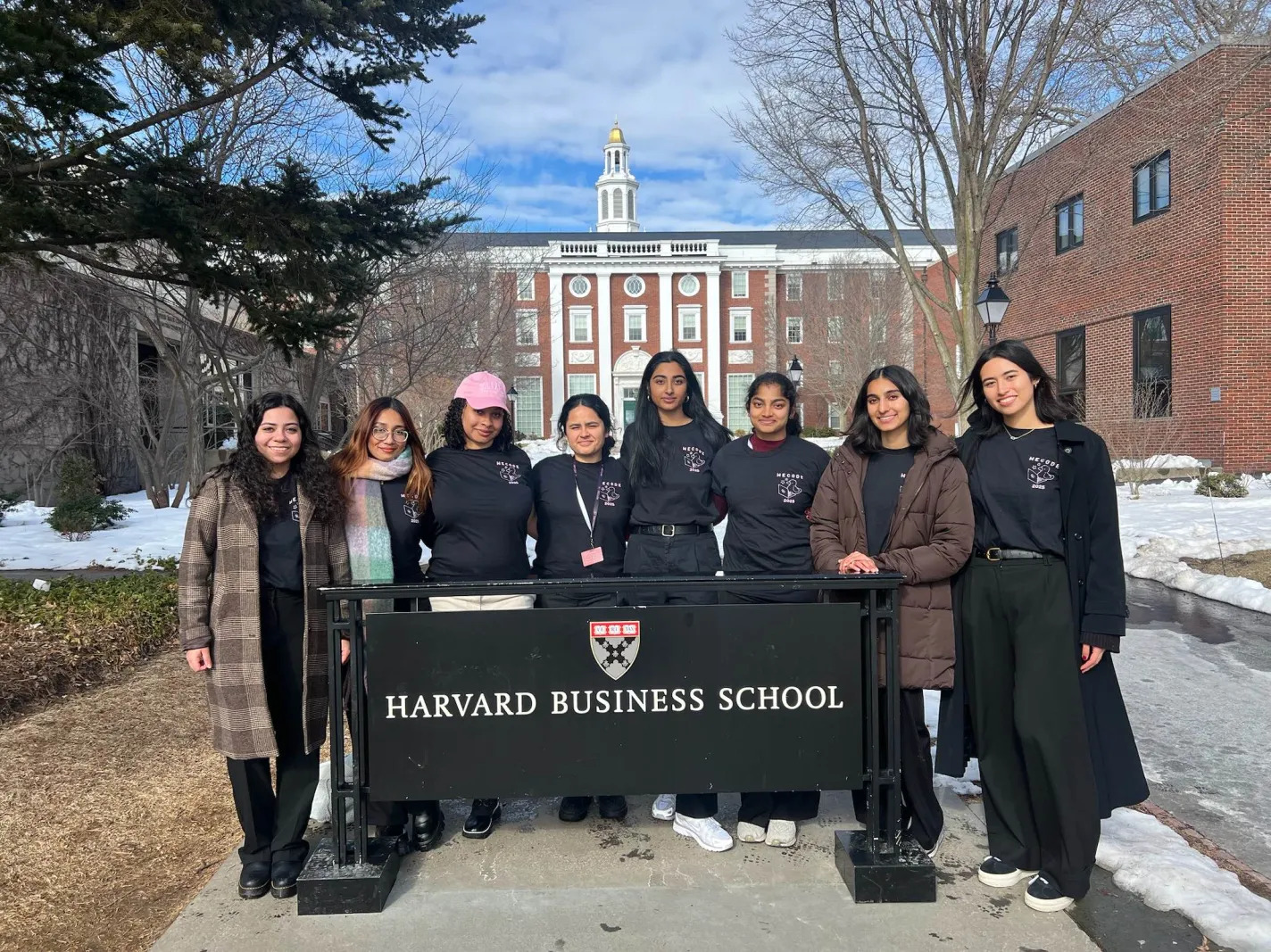 Women In Computing members standing with a banner during travel
